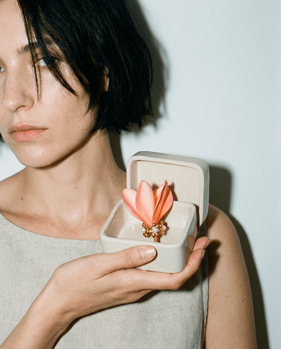 Portret z ceramicznym pudełkiem, w którym leży złoty pierścionek z perłą